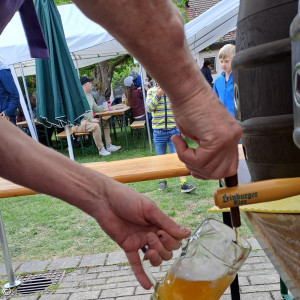 Bierkrug, der gerade am Fass aufgefüllt wird